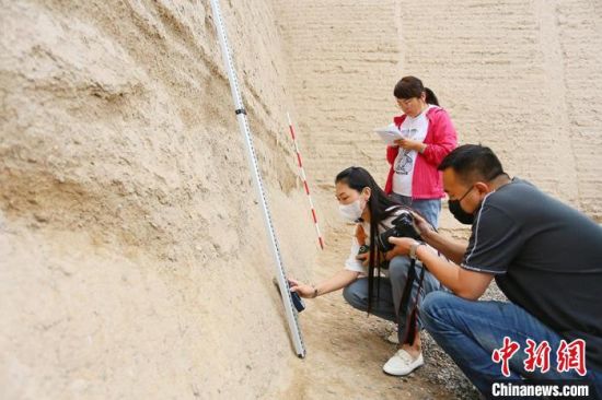 科技保護讓長城價值的真實性和完整性得到有效延續(xù)和傳承。圖為文物工作者正在測量關城的相關數(shù)據(jù)?！「哒?攝