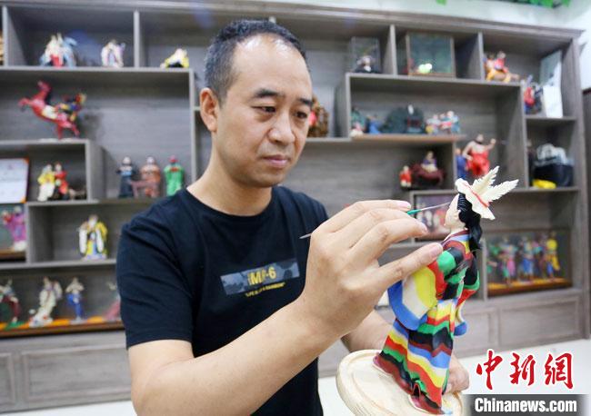 圖為安秋平正在創(chuàng)作代表隴南文縣民俗的《白馬人》作品?！「哒?攝