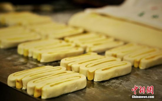 圖為面劑被涂上胡麻油，切成條狀用作月餅的花型制作。張文 攝