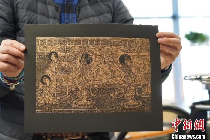 圖為手工書藝人展示敦煌雕版壁畫印刷品?！【琶赖┰?　攝