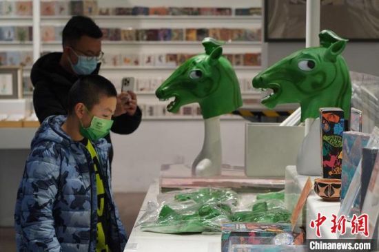 圖為“神馬來了”銅奔馬頭套吸引參觀者駐足?！【琶赖┰?攝