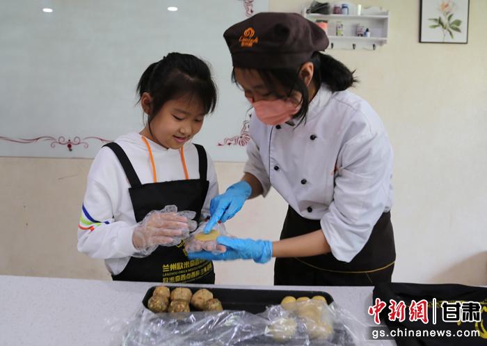 圖為在甘臺胞小朋友在工作人員指導(dǎo)下制作月餅。九美旦增 攝