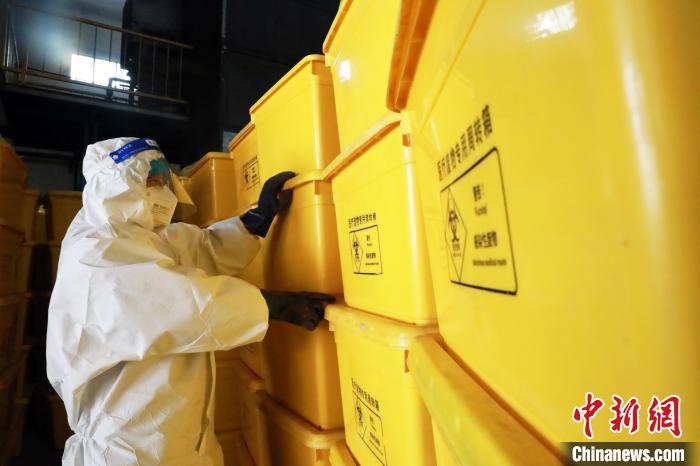 圖為工作人員搬運(yùn)醫(yī)療廢物專用周轉(zhuǎn)箱?！∥航ㄜ?攝