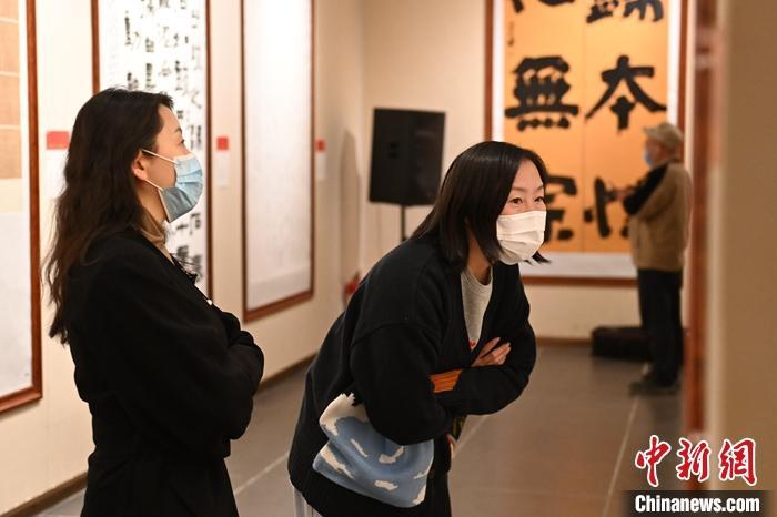 圖為甘肅蘭州，參展書(shū)法作品吸引參觀者。 中新社記者 李亞龍 攝