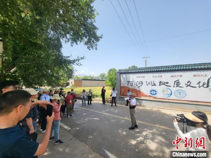 圖為中國地質(zhì)大學(xué)(北京)教授張緒教介紹村落情況?！『衍?攝