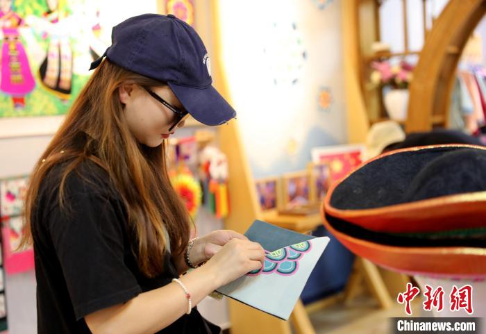 圖為民眾體驗國家級非遺項目盤繡技藝?！⊙Φ?攝