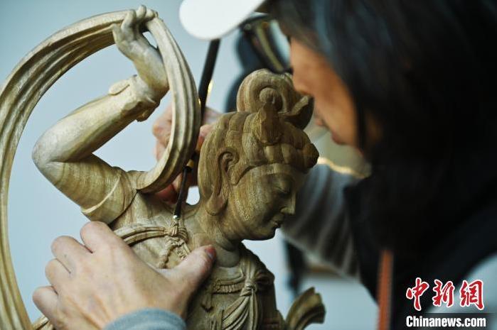 圖為季茂杰進行敦煌元素的木雕創(chuàng)作。李亞龍 攝</p>
<p>