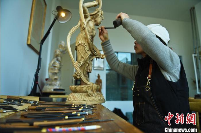 圖為季茂杰進行敦煌元素的木雕創(chuàng)作。李亞龍 攝</p>
<p>