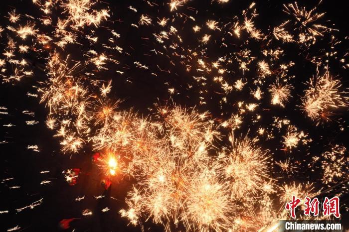 灼熱的鐵水在空中迸散。在空中形成“鐵花火雨”的景象，似天女散花，似群星漫天，如夢如幻，美不勝收。侯奇志 攝</p>
<p>