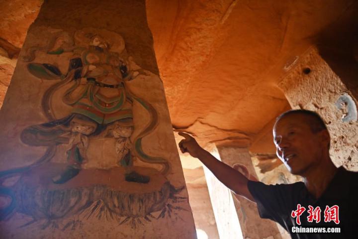 7月15日，甘肅省平?jīng)鍪袥艽h百里石窟長廊羅漢洞石窟內(nèi)，該窟文保員郭建平介紹窟內(nèi)石刻彩繪壁畫。郭建平家中三代人曾自發(fā)保護(hù)羅漢洞石窟。羅漢洞石窟遺存40余個(gè)窟龕，以北魏至清代風(fēng)格為主。中新社記者 李亞龍 攝</p>
<p>