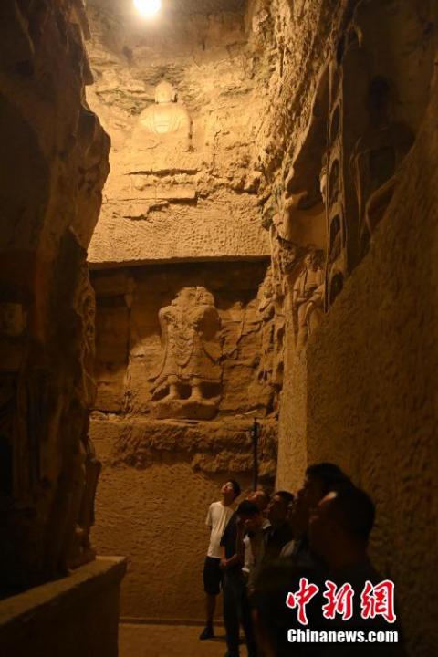 7月15日，游人參觀甘肅省平?jīng)鍪袥艽h百里石窟長廊中的王母宮石窟。百里石窟長廊位于涇川縣境內(nèi)，由512個(gè)石窟、5眼窟中石井組成，現(xiàn)存王母宮石窟、鳳凰山石窟、南石窟寺、丈八寺石窟、羅漢洞石窟、太山寺石窟等規(guī)模較大的石窟群，還有數(shù)量眾多的小石窟群。王母宮石窟又名千佛洞，該窟設(shè)計(jì)宏大，造像生動(dòng)，窟內(nèi)擁有造像數(shù)百尊，是較為珍貴的佛教文化遺存。中新社記者 李亞龍 攝</p>
<p>