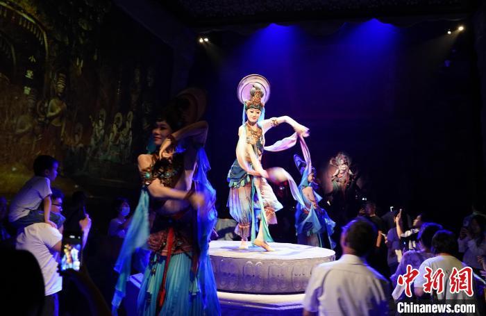 《樂(lè)動(dòng)敦煌》是全球首部洞窟式沉浸體驗(yàn)劇，利用真人與數(shù)字影像虛實(shí)交換實(shí)現(xiàn)沉浸式體驗(yàn)。圖為2023年8月28日晚，《樂(lè)動(dòng)敦煌》演出。(資料圖)中新社記者 毛建軍 攝